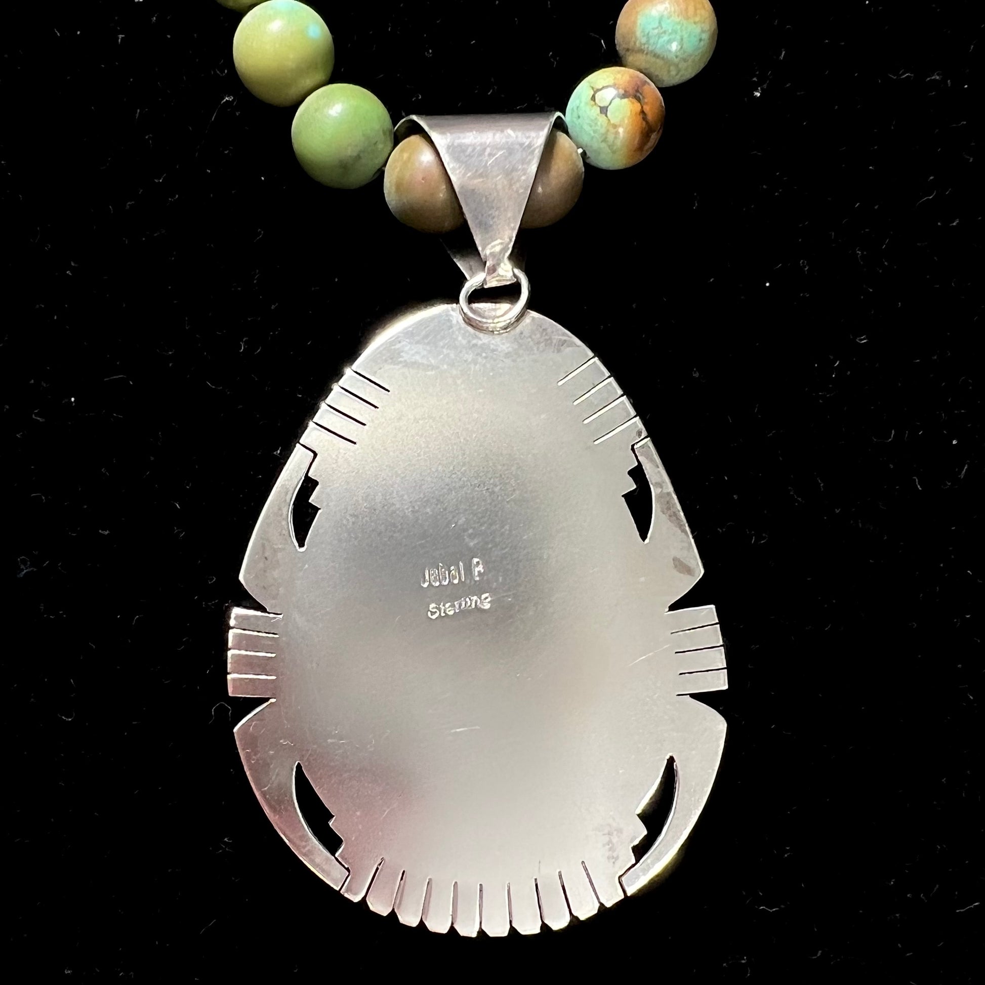 A handmade, likely Navajo silver pendant set with Kingman turquoise on a green Kingman turquoise beaded necklace.