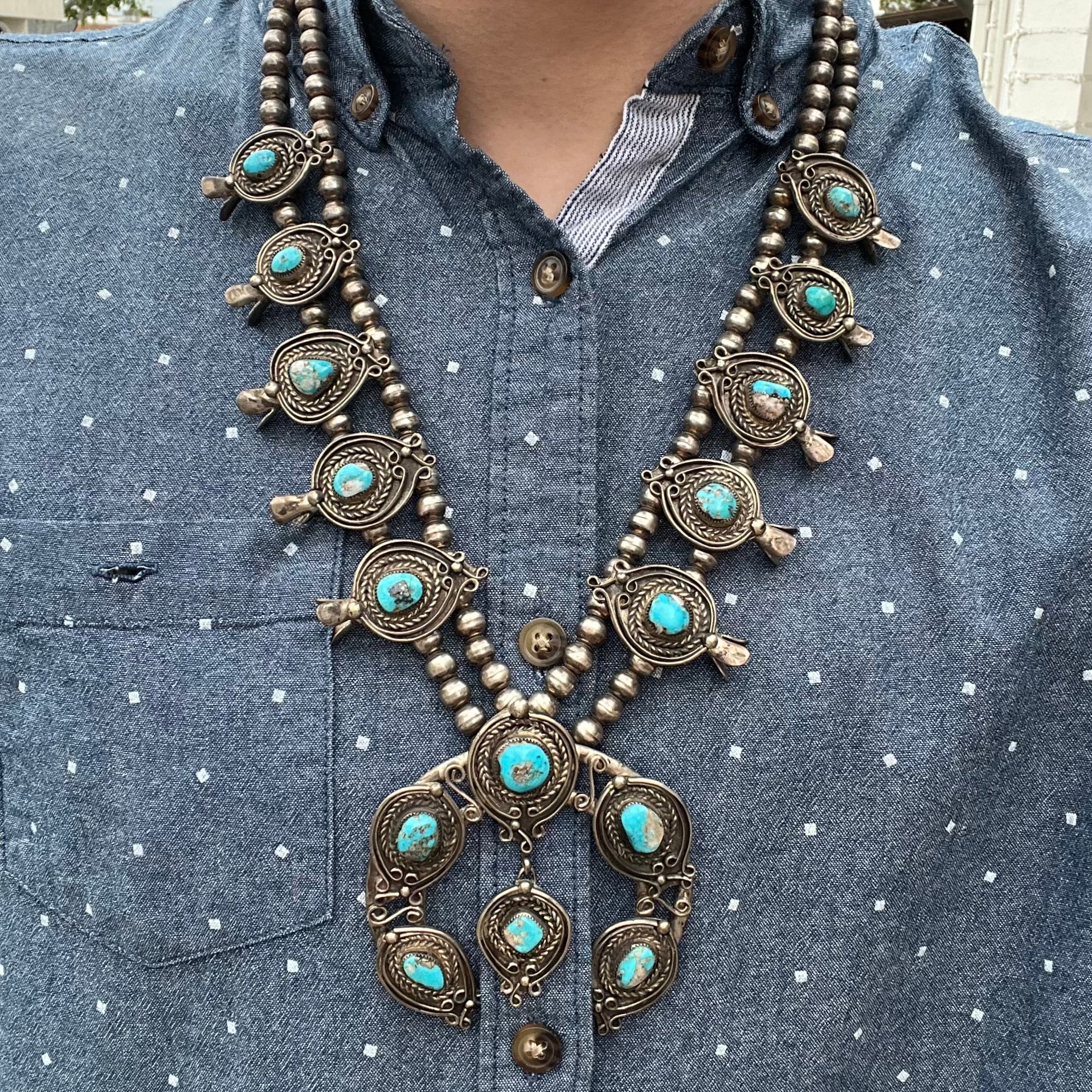 A men's Navajo silver squash blossom necklace set with Kingman turquoise stones.