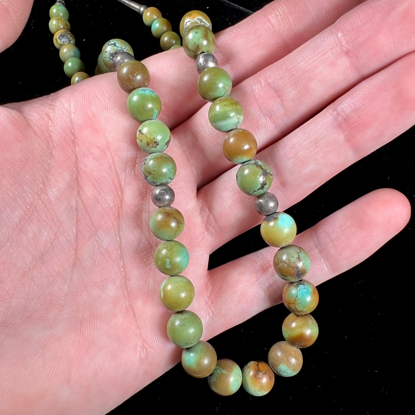 A handmade, likely Navajo silver pendant set with Kingman turquoise on a green Kingman turquoise beaded necklace.
