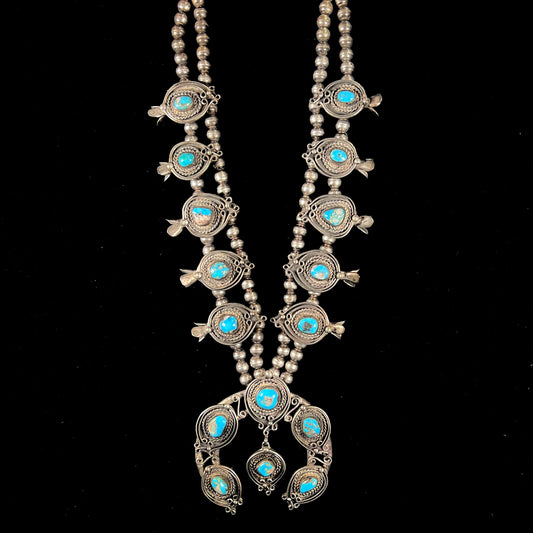 A men's Navajo silver squash blossom necklace set with Kingman turquoise stones.