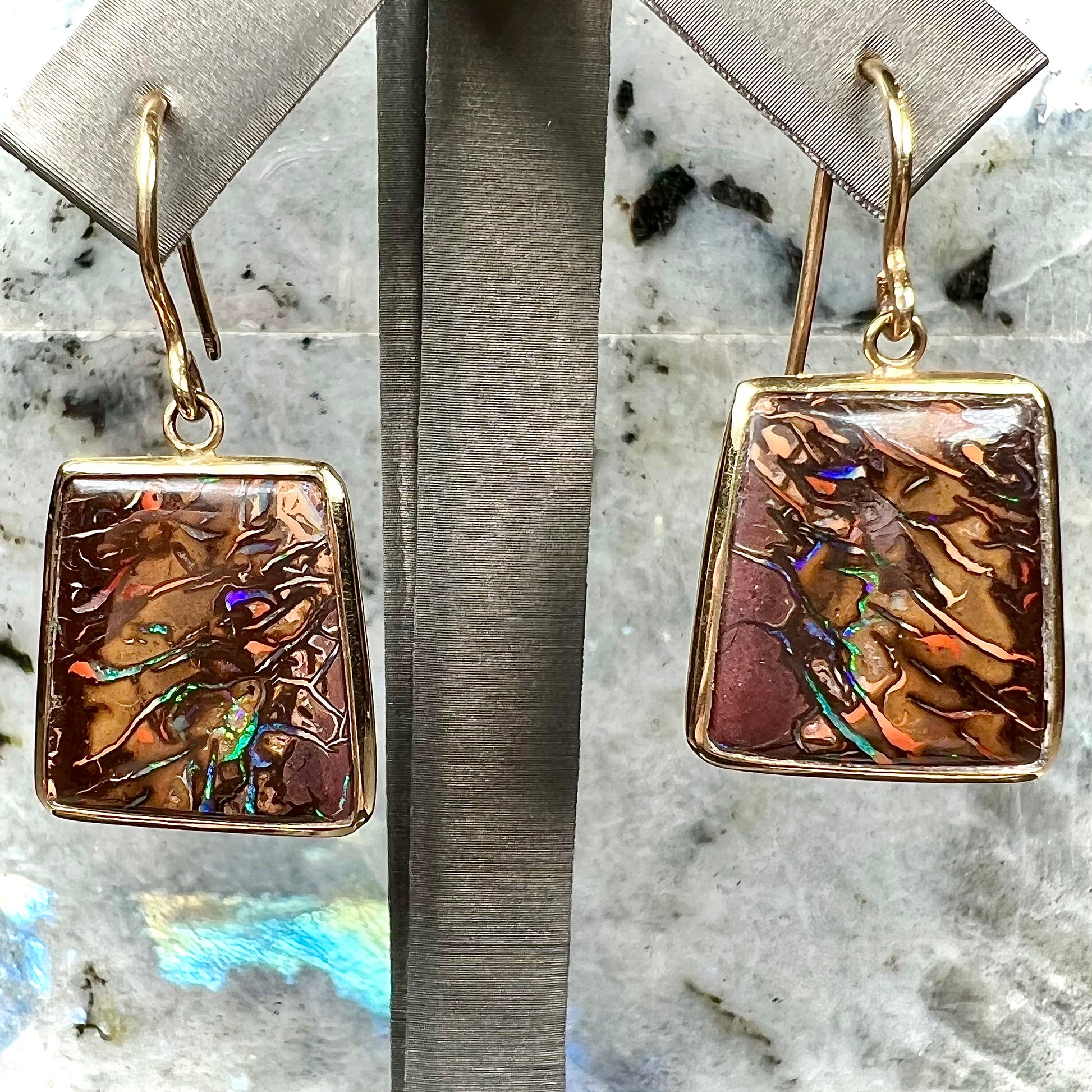A pair of yellow gold French wire dangle earrings set with Koroit boulder opal.
