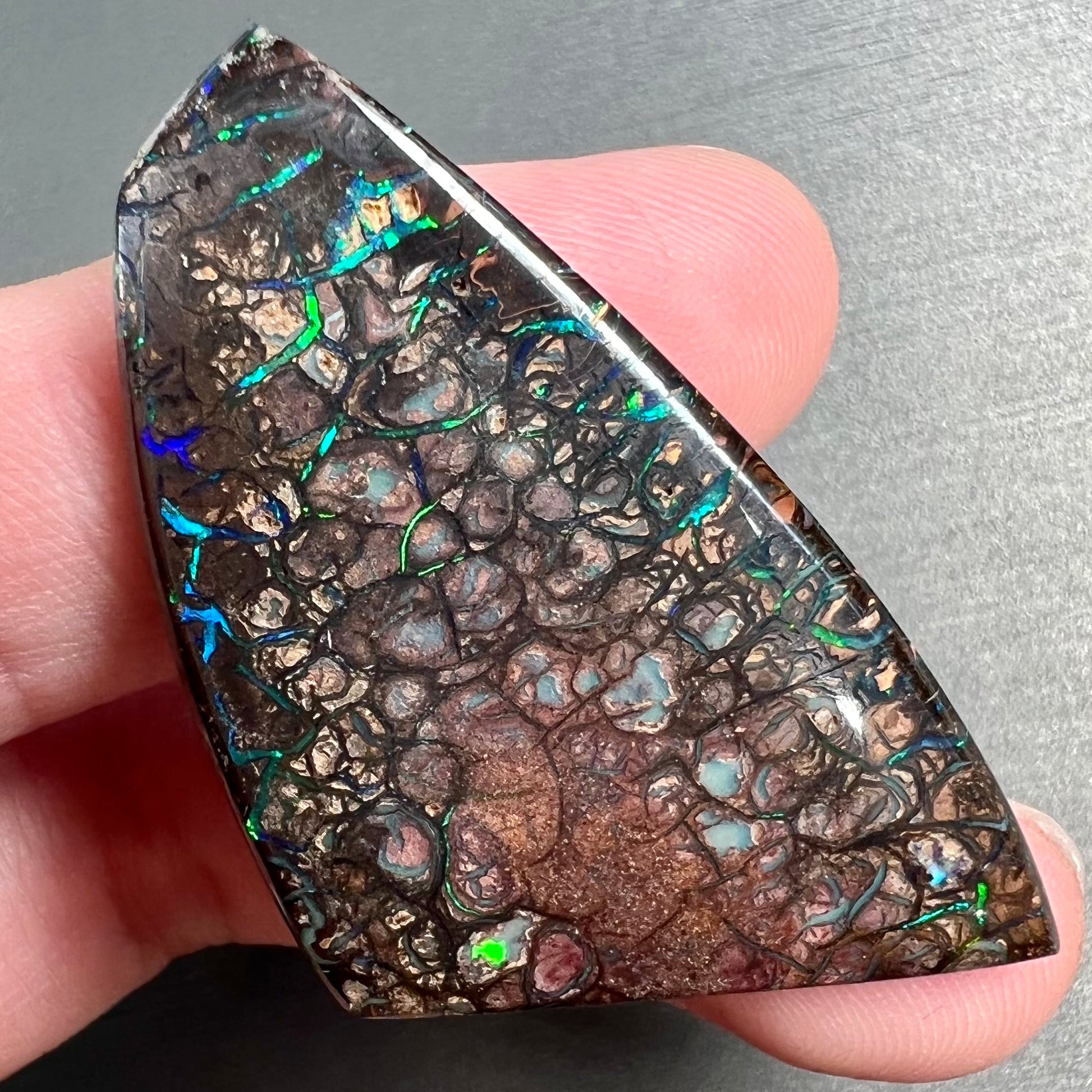 A loose, freeform cut polished Koroit boulder opal stone from Koroit Mining District, Australia.