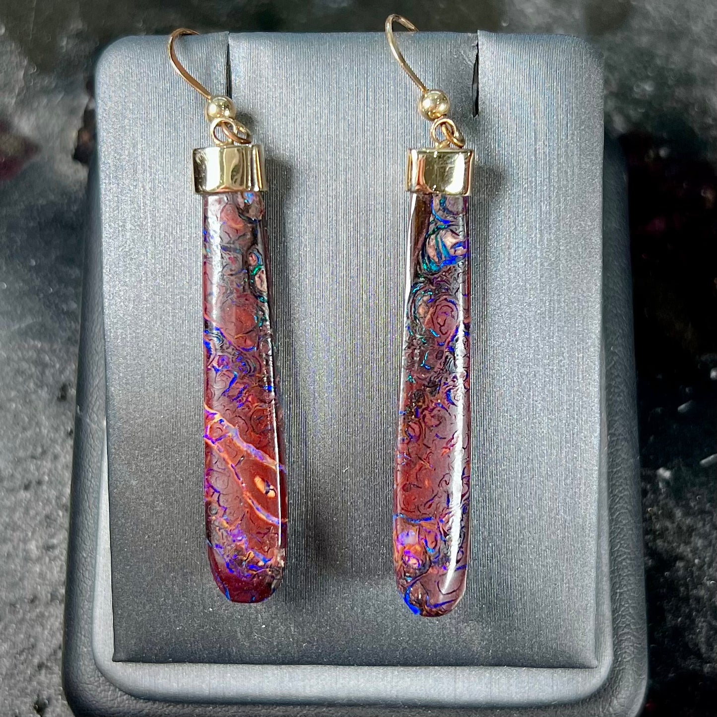 A pair of yellow gold cap Koroit boulder opal dangle earrings.  Purple highlights are seen.