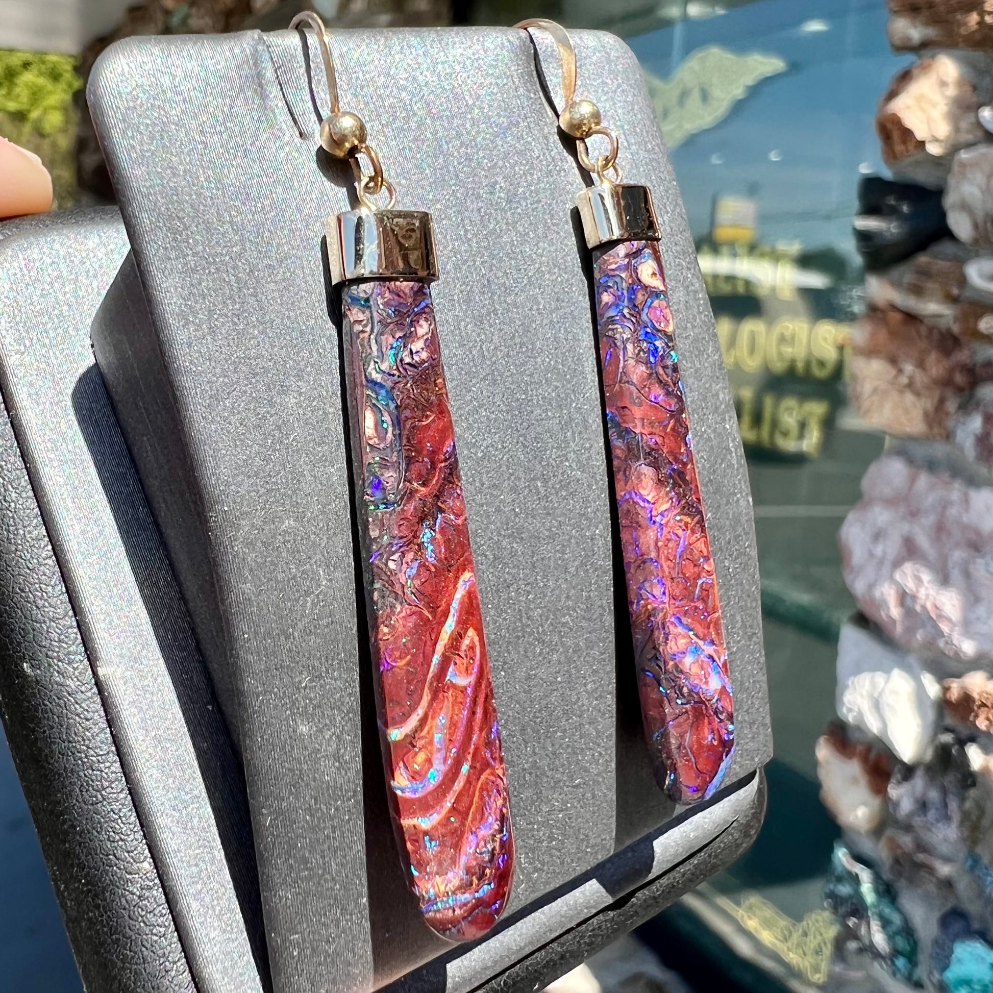 A pair of yellow gold cap Koroit boulder opal dangle earrings.  Purple highlights are seen.