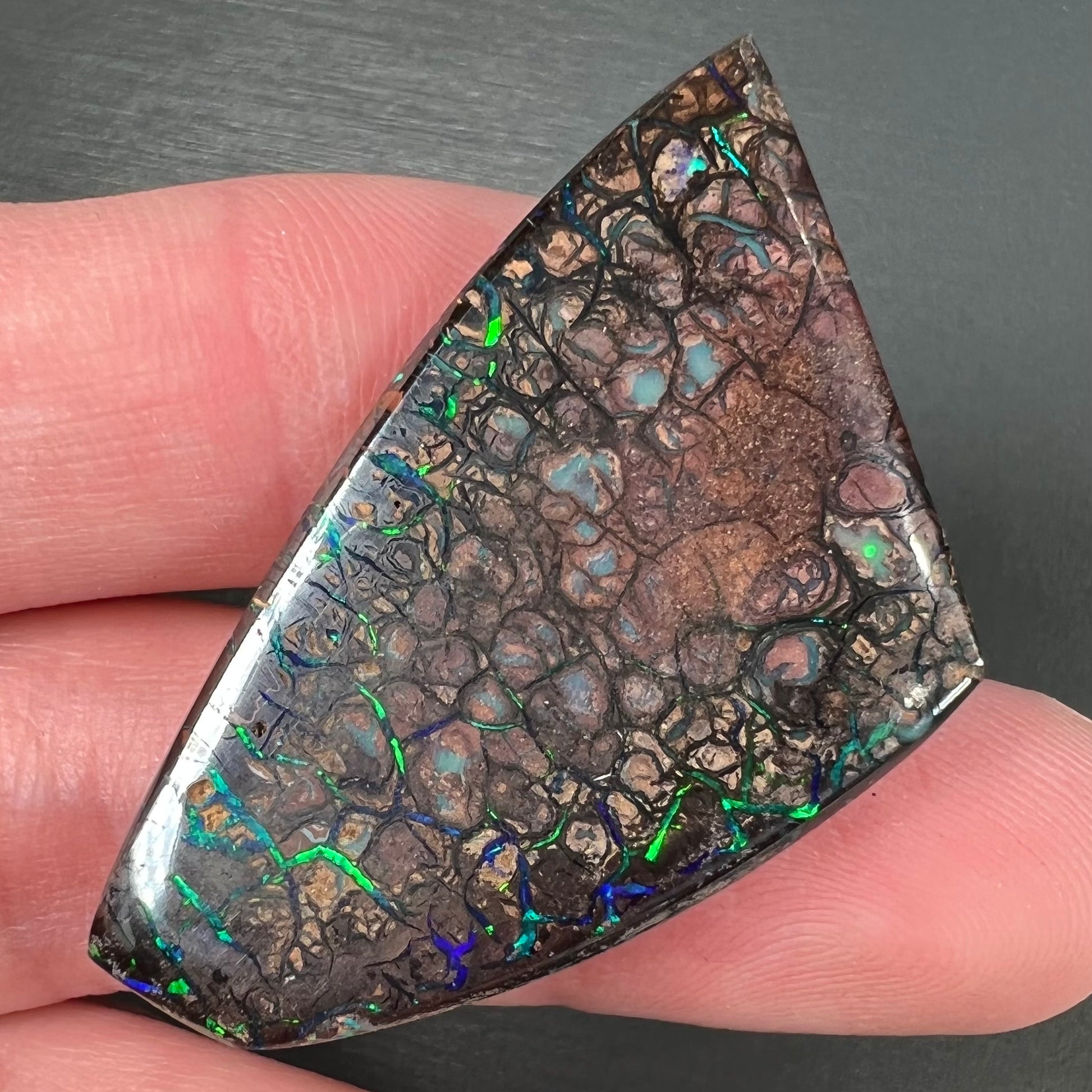 A loose, freeform cut polished Koroit boulder opal stone from Koroit Mining District, Australia.