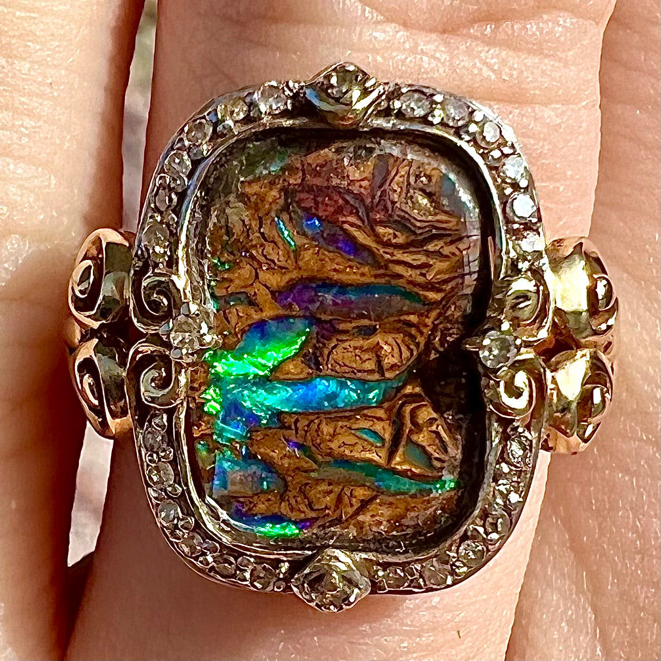 Striped Koroit boulder opal set in a filigree 14k yellow gold setting with diamonds.  The filigree has a heart pattern.