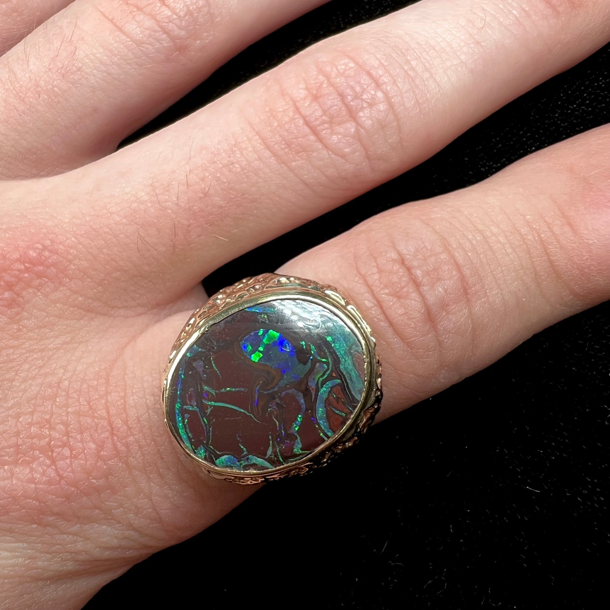 A men's yellow gold nugget style Koroit boulder opal solitaire ring.