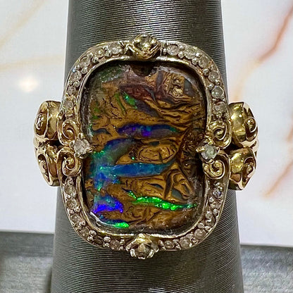 Striped Koroit boulder opal set in a filigree 14k yellow gold setting with diamonds.  The filigree has a heart pattern.