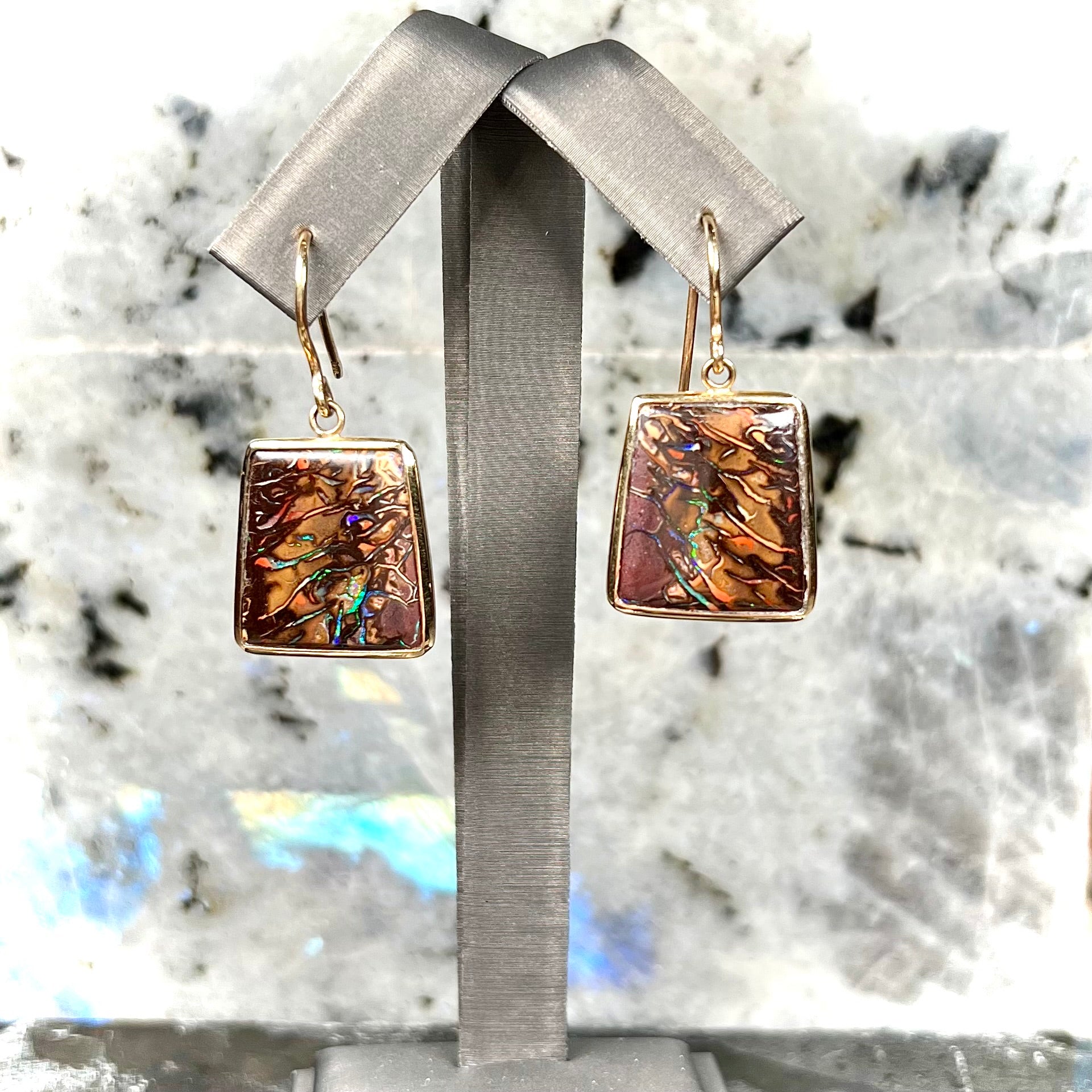 A pair of yellow gold French wire dangle earrings set with Koroit boulder opal.
