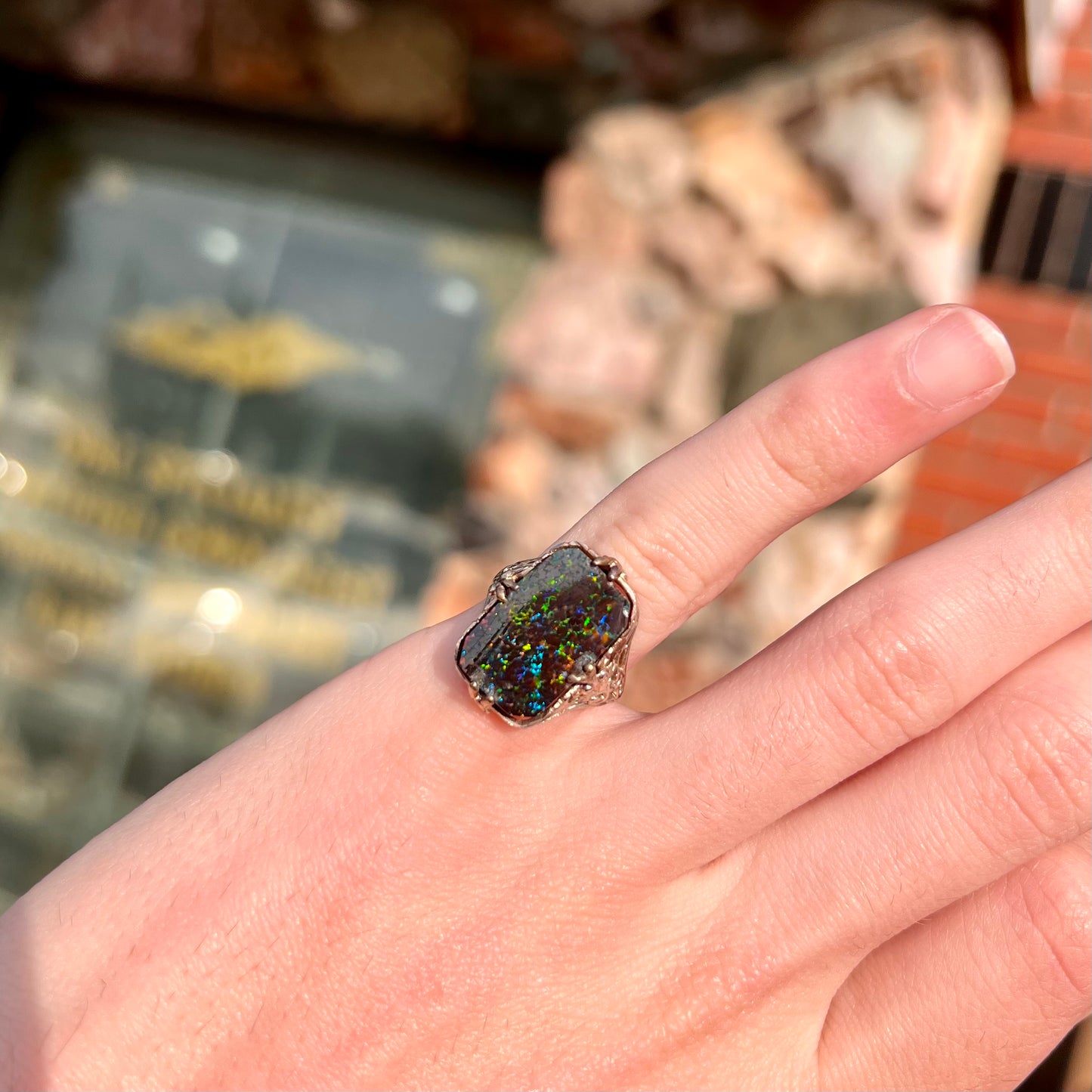 A vintage, white gold filigree unisex ring set with a black Koroit boulder opal.