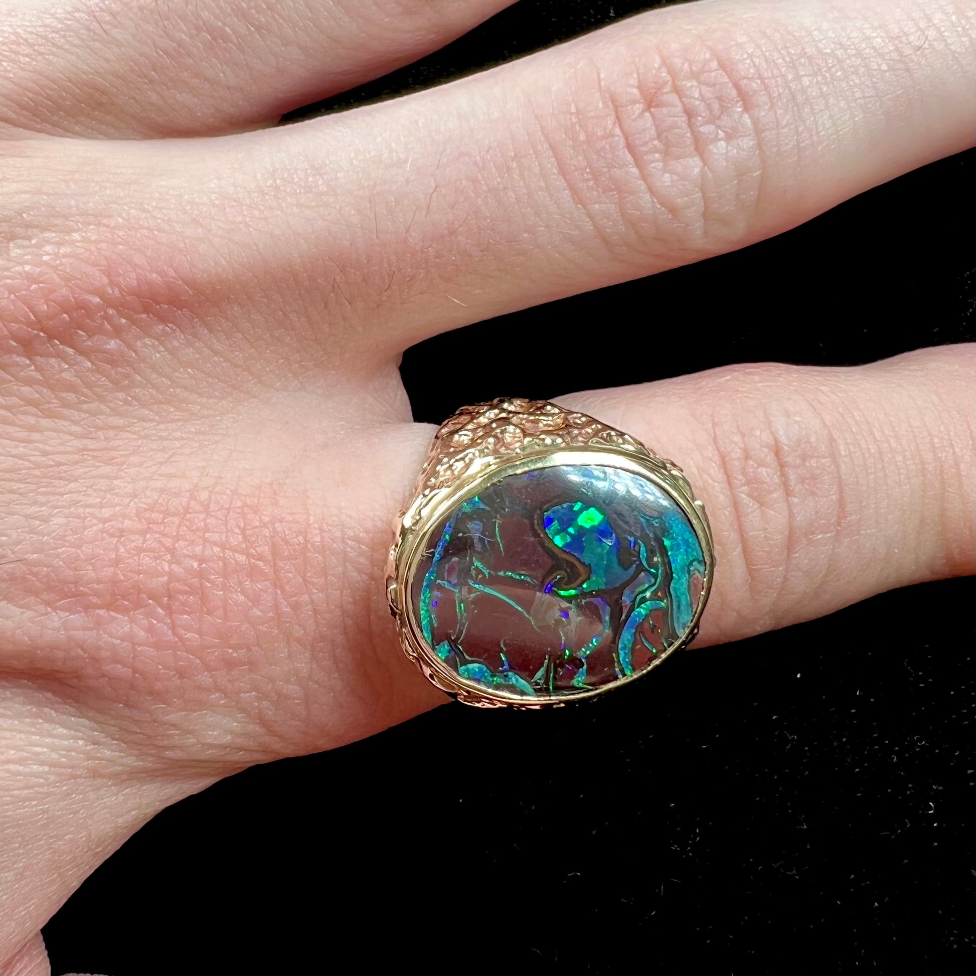 A men's yellow gold nugget style Koroit boulder opal solitaire ring.