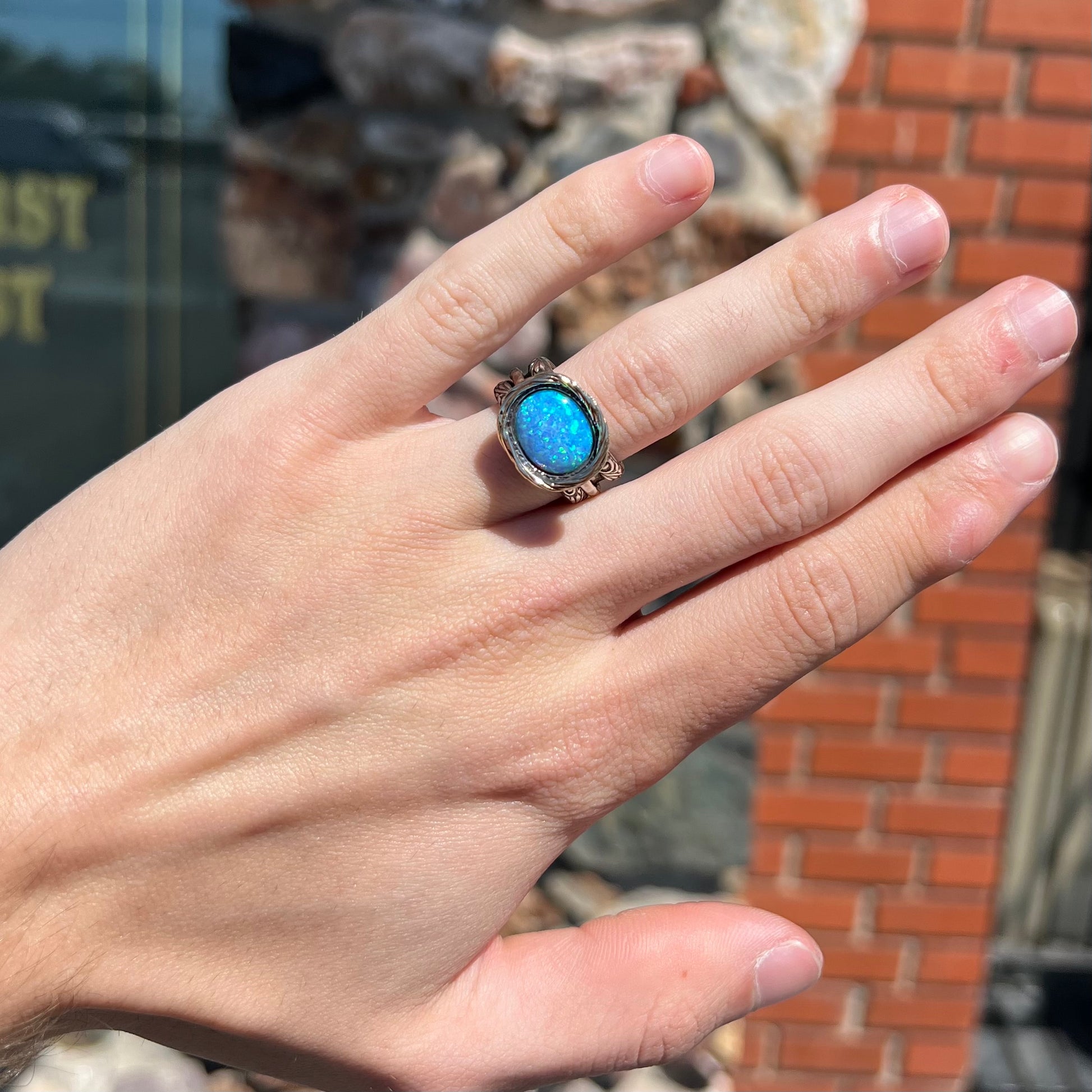 A filigree etched two tone silver and gold spinner ring set with a lab created black opal.