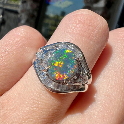 A platinum Lightning Ridge black opal ring set with baguette cut diamonds.  The opal is an oval cabochon cut.