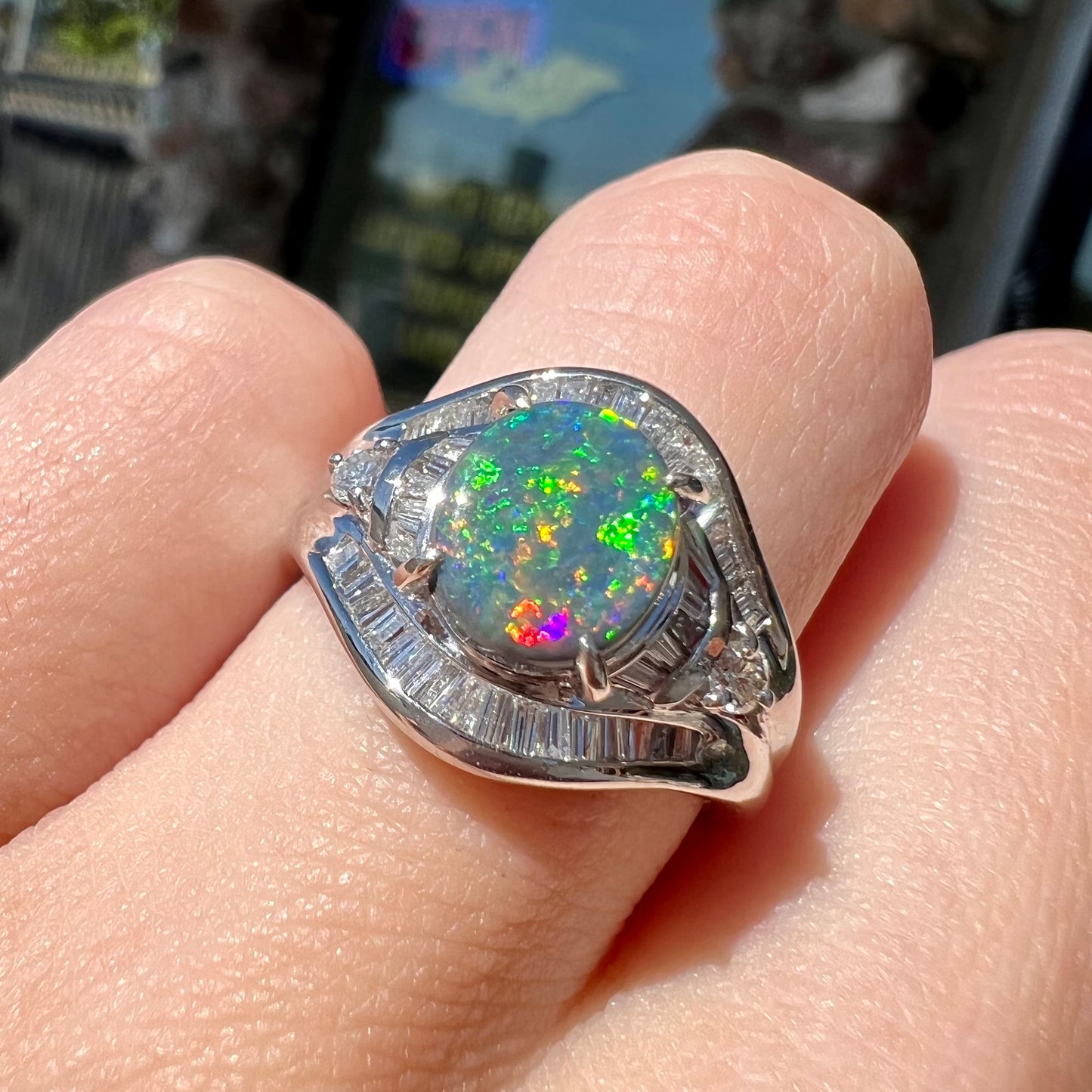 A platinum Lightning Ridge black opal ring set with baguette cut diamonds.  The opal is an oval cabochon cut.