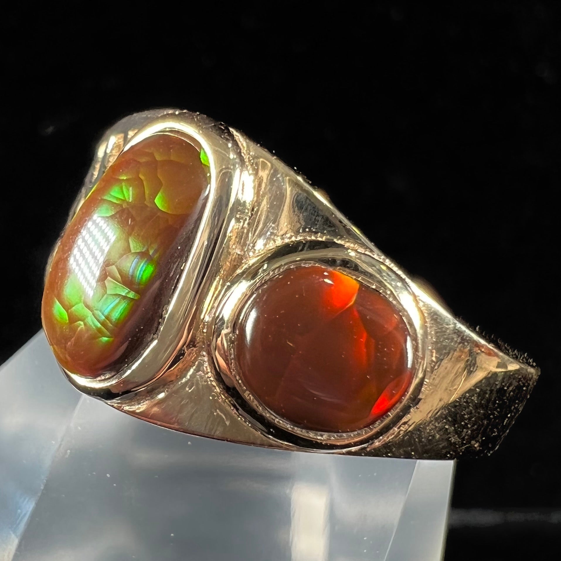 A ladies' yellow gold ring set with two fire agate stones: one green, and one red.
