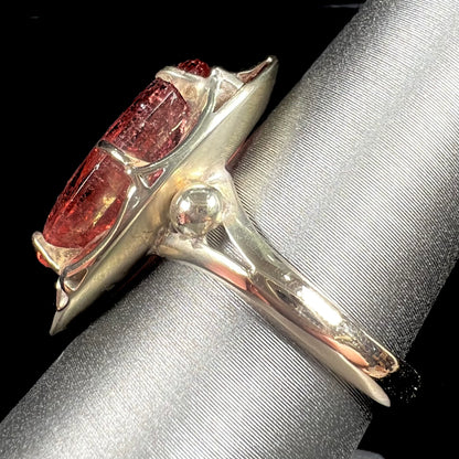 A yellow gold solitaire ring set with an oval cut, rootbeer colored tourmaline stone.
