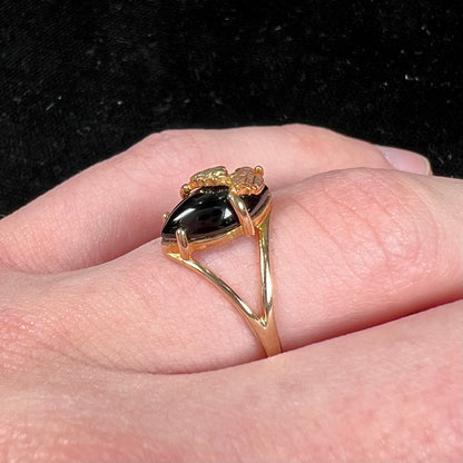 A split shank Black Hills gold ring set with a cabochon marquise cut black onyx.