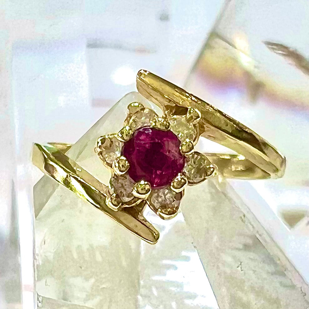 Custom twisted shank ruby and diamond halo yellow gold ring.