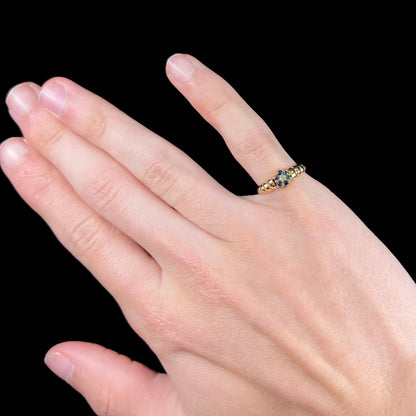 A ladies' yellow gold cluster ring set with round blue sapphires and a round diamond.