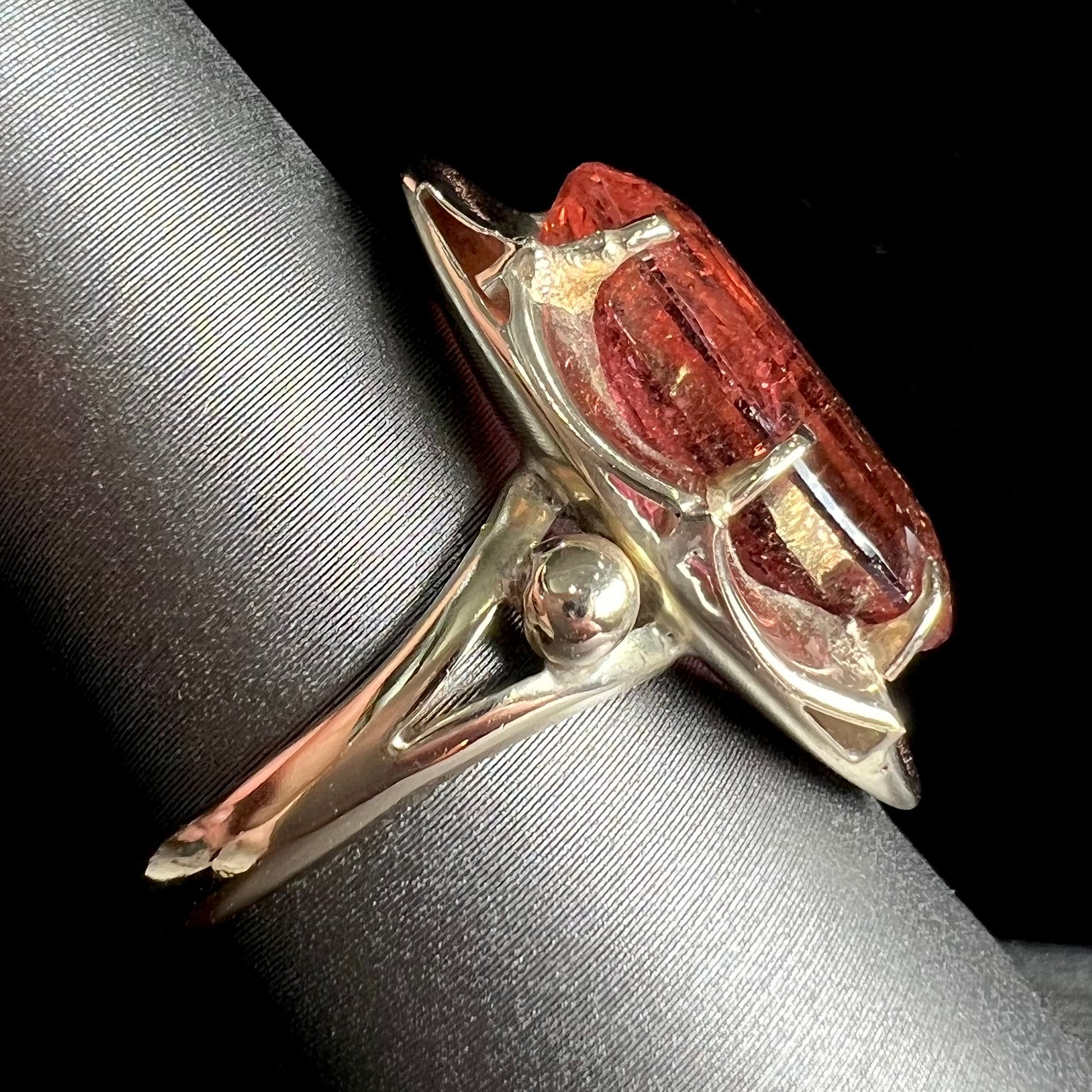 A yellow gold solitaire ring set with an oval cut, rootbeer colored tourmaline stone.