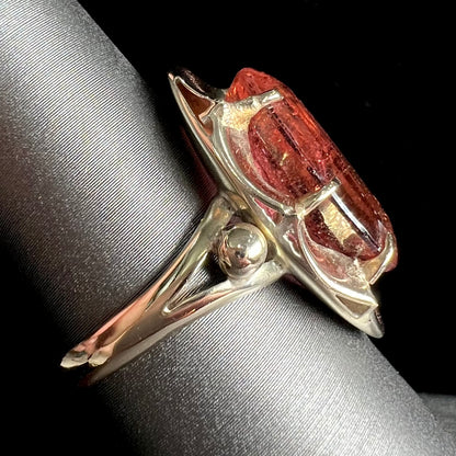 A yellow gold solitaire ring set with an oval cut, rootbeer colored tourmaline stone.