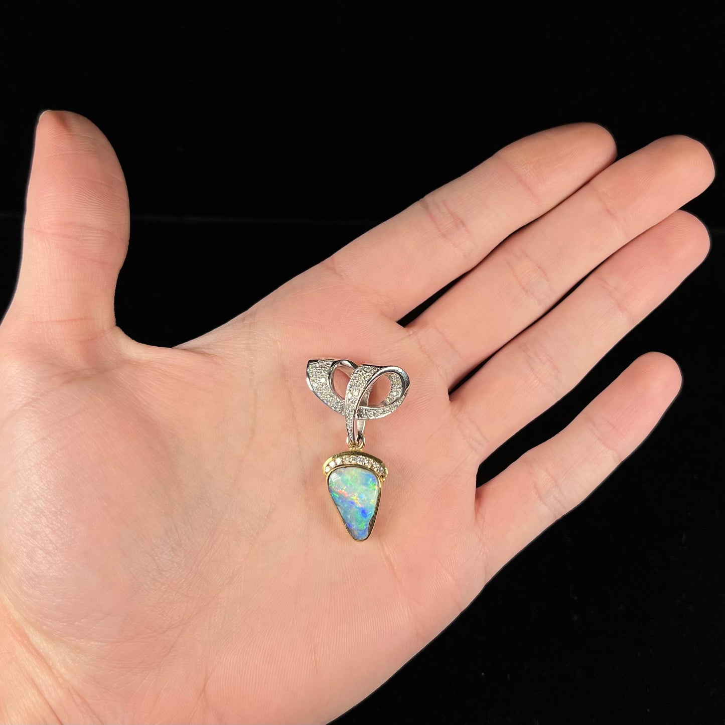 A ladies' 18kt two tone white and yellow gold Australian black boulder opal and diamond pendant.