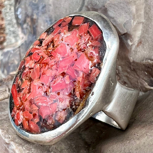 A rustic style, handmade silver men's ring set with crushed red coral.