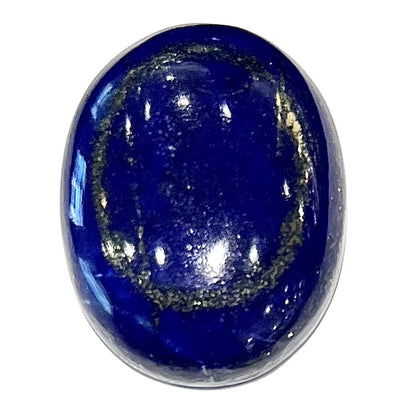 A loose, oval cabochon cut lapis lazuli stone.  A circle of pyrite inclusions is seen on the front.