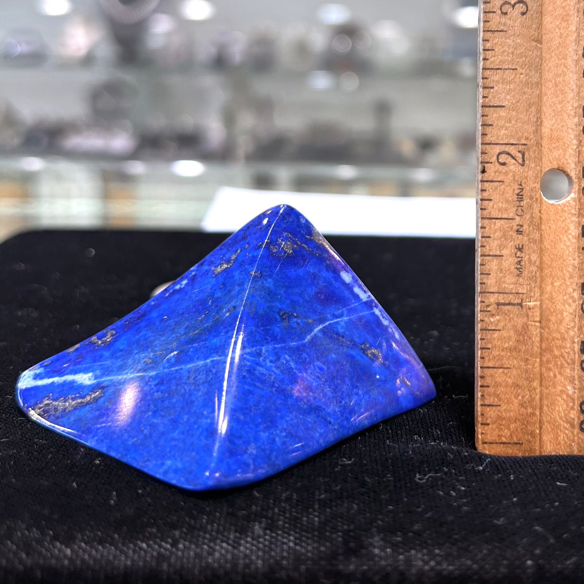 A loose polished sculpture made from royal blue lapis lazuli with golden pyrite inclusions.