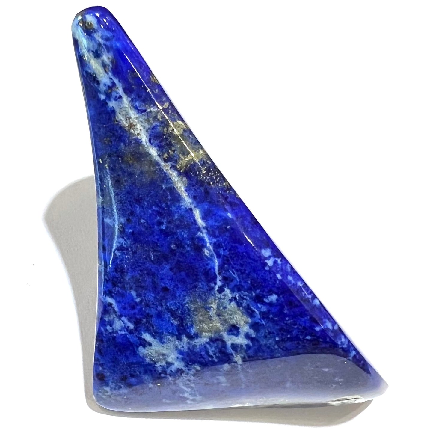 A loose polished sculpture made from royal blue lapis lazuli with golden pyrite inclusions.