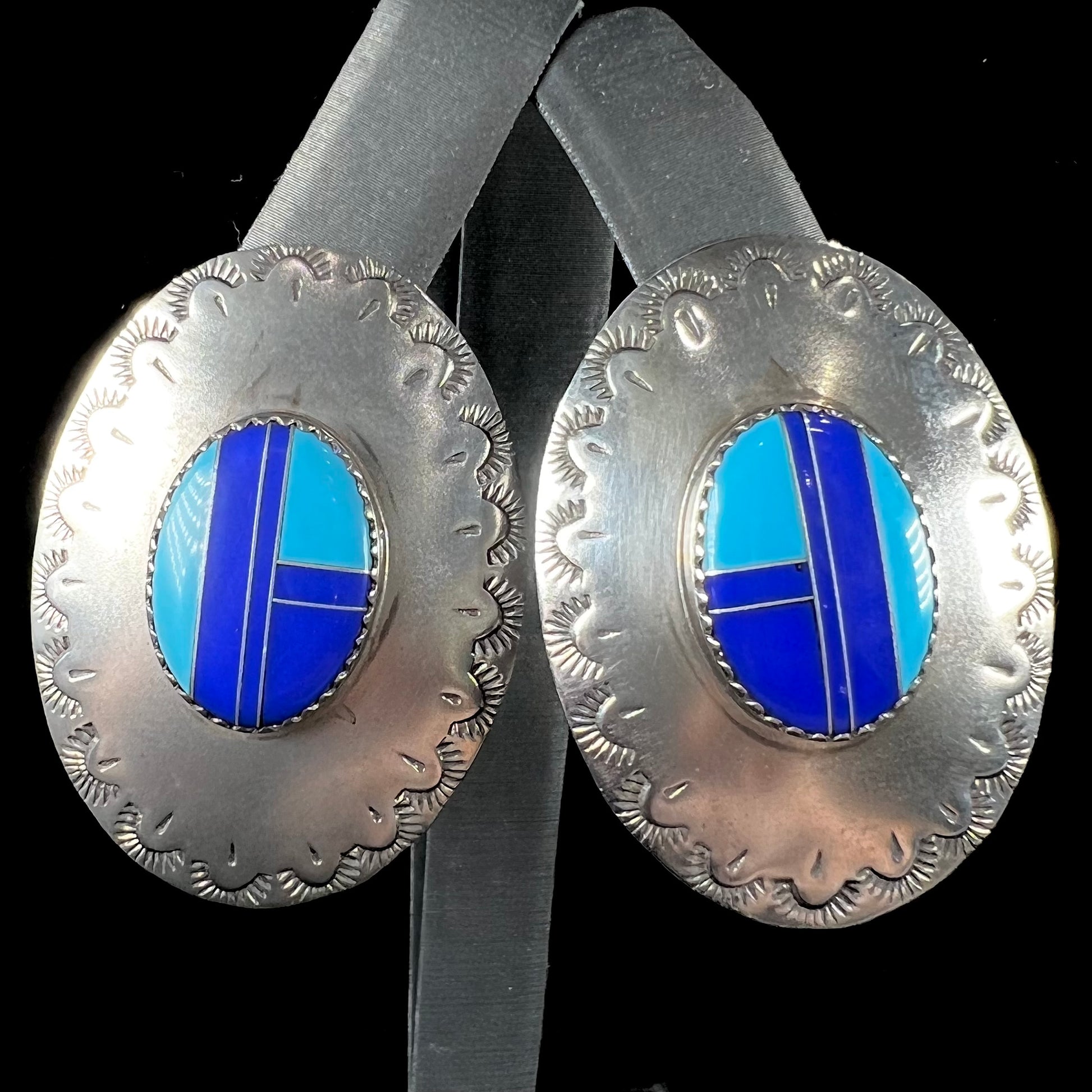 A pair of sterling silver concho earrings set with lapis lazuli and turquoise stone inlay.