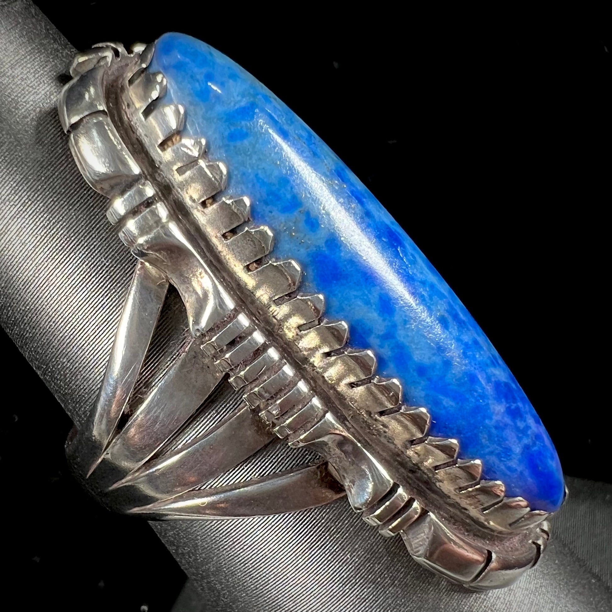 A Navajo style sterling silver lapis lazuli ring engraved with the words "R. Bennett".