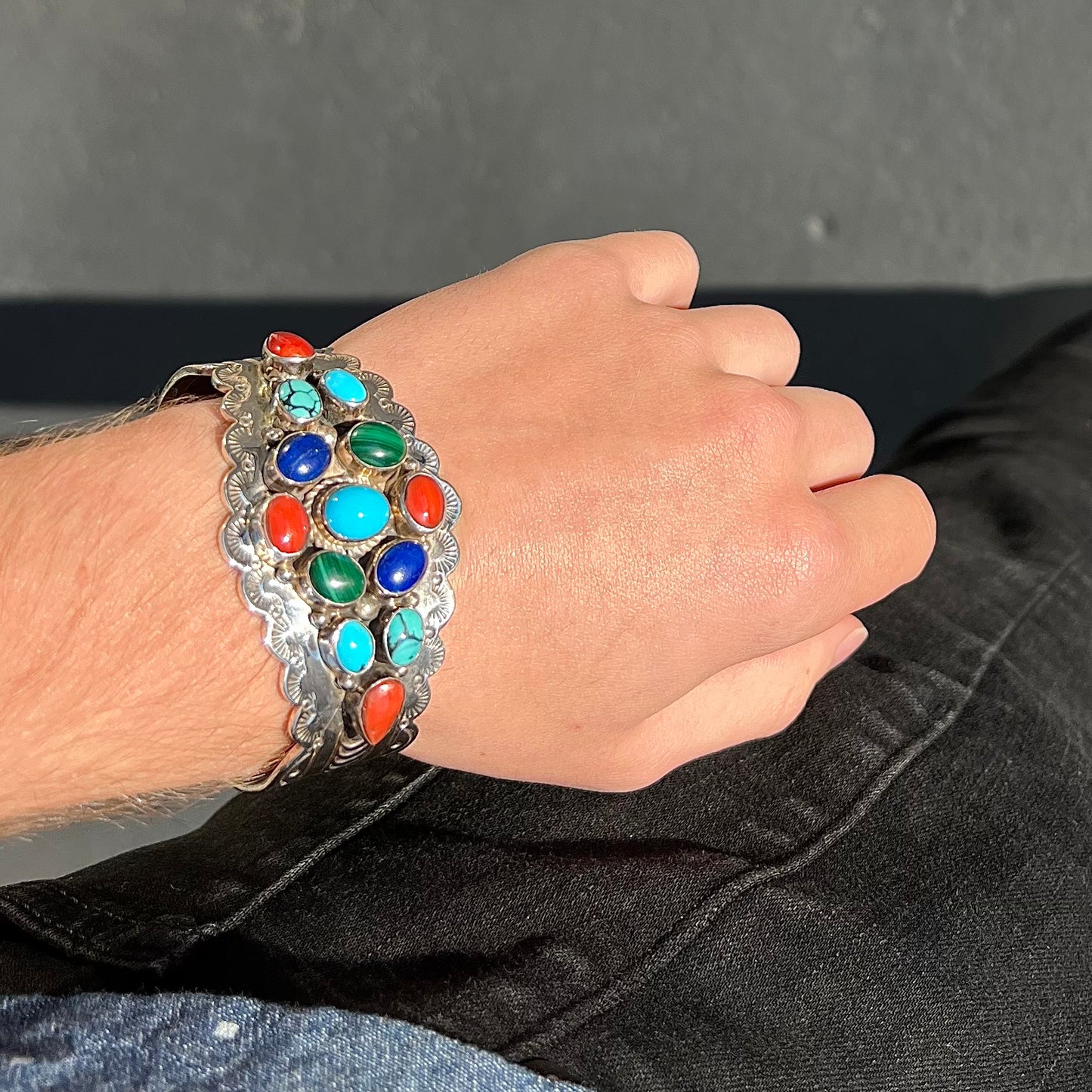 A sterling silver ladies' Navajo cuff bracelet set with turquoise, malachite, lapis lazuli, and coral stones.