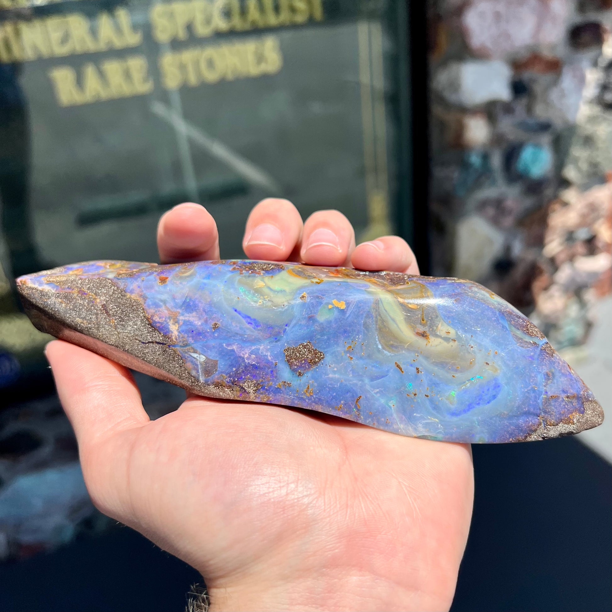 A 7 inch long polished blue Quilpie boulder opal specimen from Queensland, Australia.