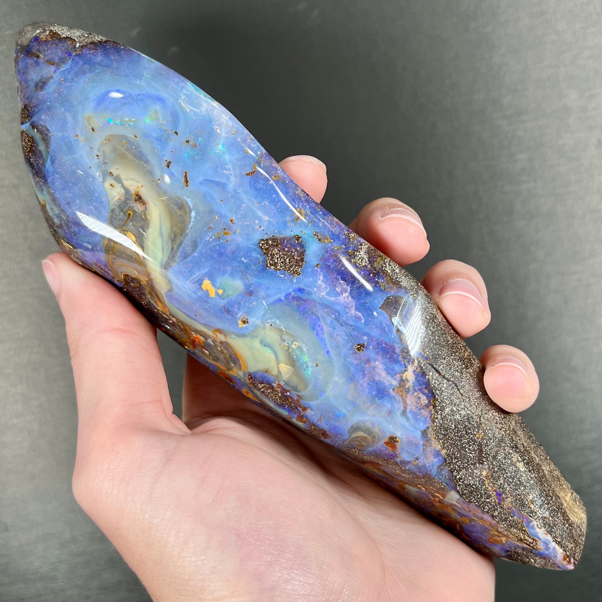 A 7 inch long polished blue Quilpie boulder opal specimen from Queensland, Australia.