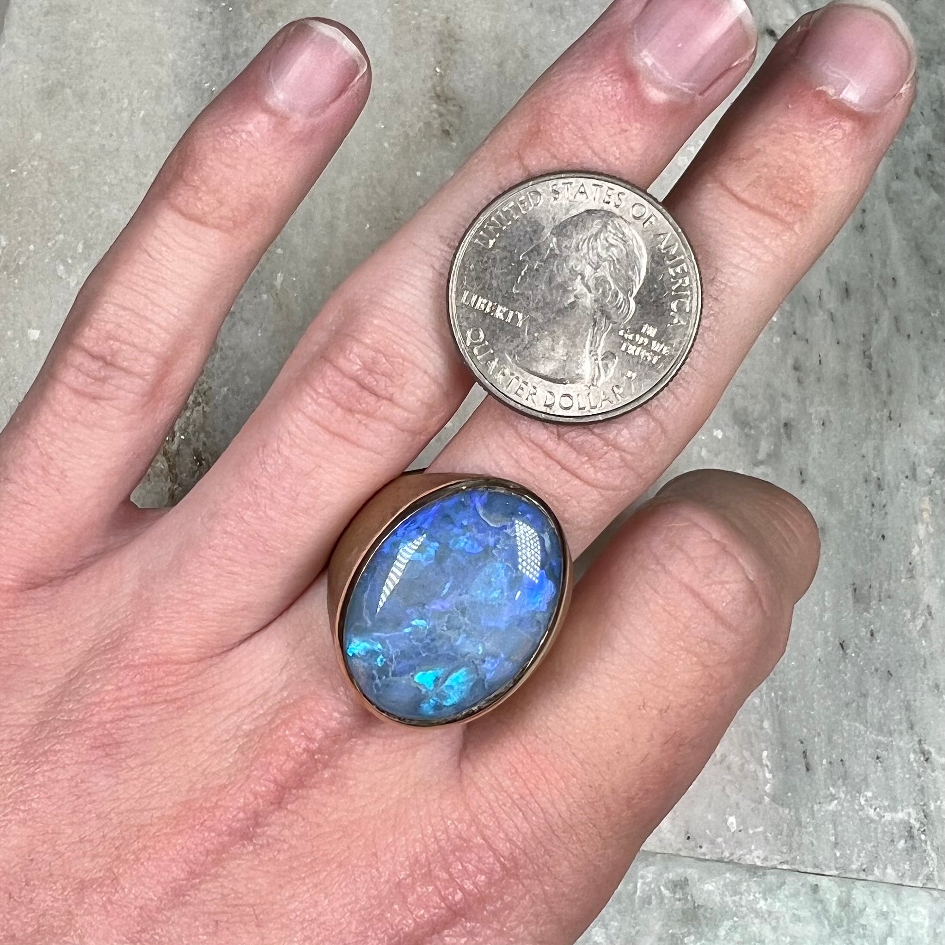 A Lightning Ridge black opal men's ring in solid yellow textured gold.