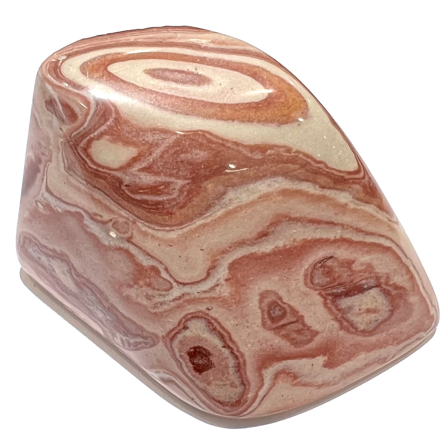 A polished piece of pinkish red picture jasper.  The stone displays a bull's eye pattern.