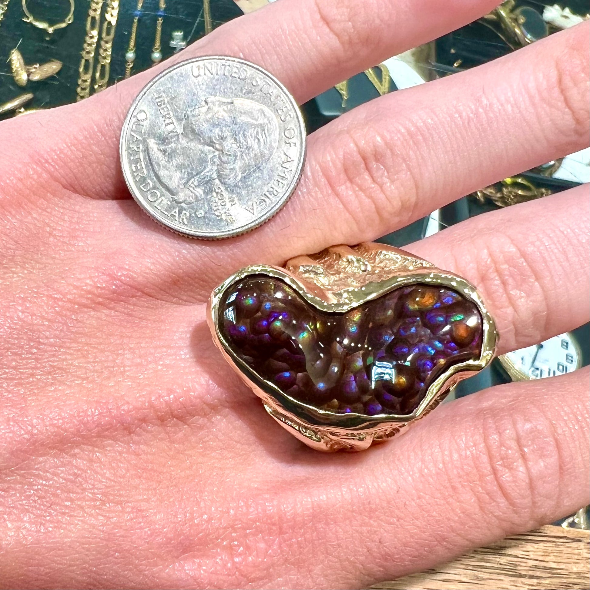 A men's Deer Creek fire agate solitaire ring cast in yellow gold.  The stone is predominantly purple.