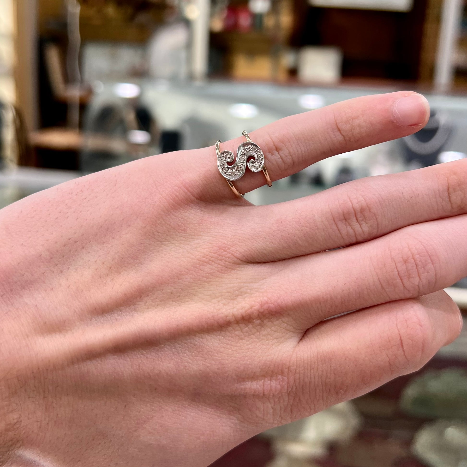 A two tone white and yellow gold initial ring of the letter "S" set with diamonds.