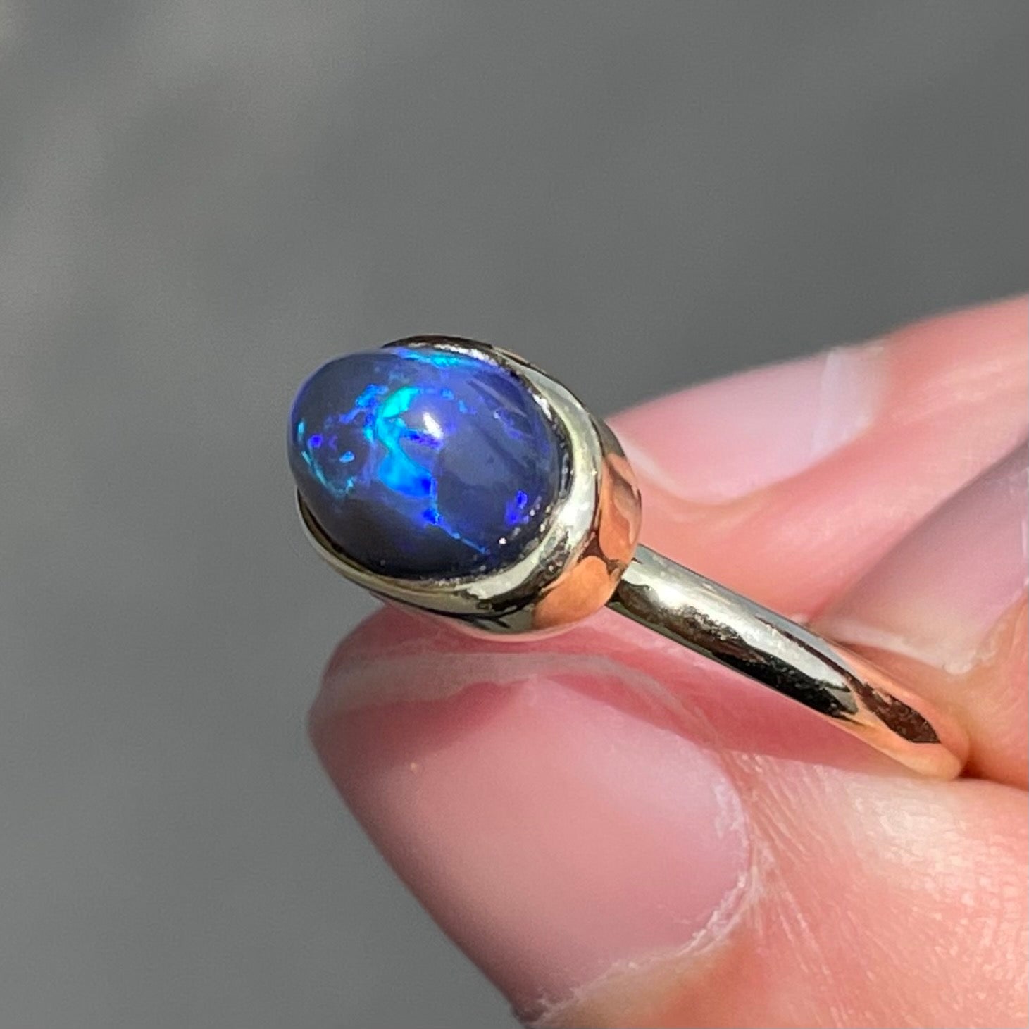 A ladies' black crystal opal solitaire ring set in yellow gold.