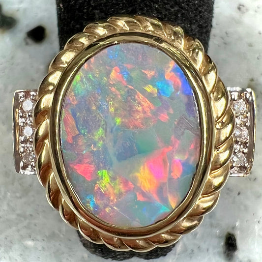 A ladies' Lightning Ridge semi-black opal ring cast in yellow gold and set with diamond accents.