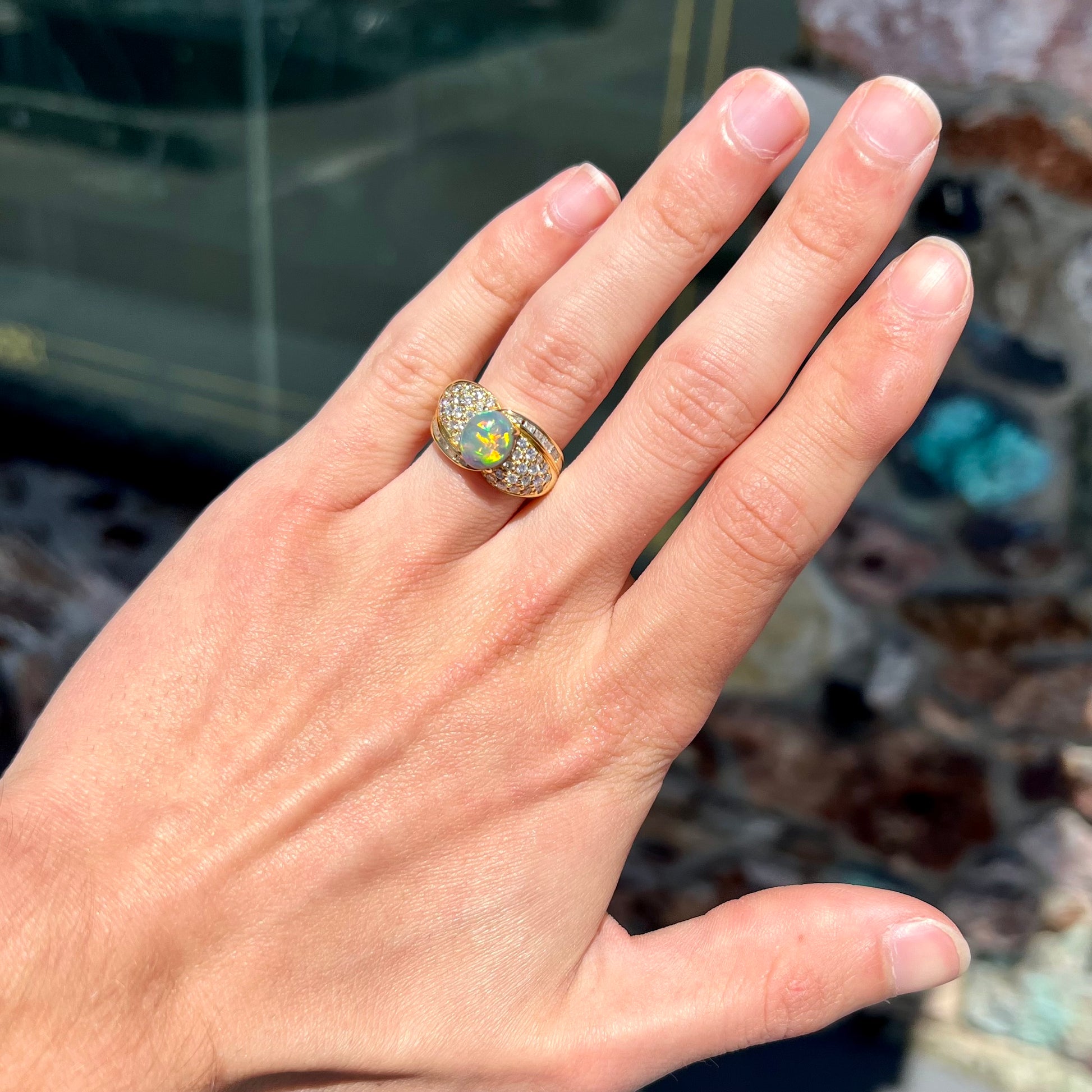 An 18kt yellow gold oval cabochon cut Lightning Ridge black opal ring.  The shank is set with round and baguette cut diamonds.