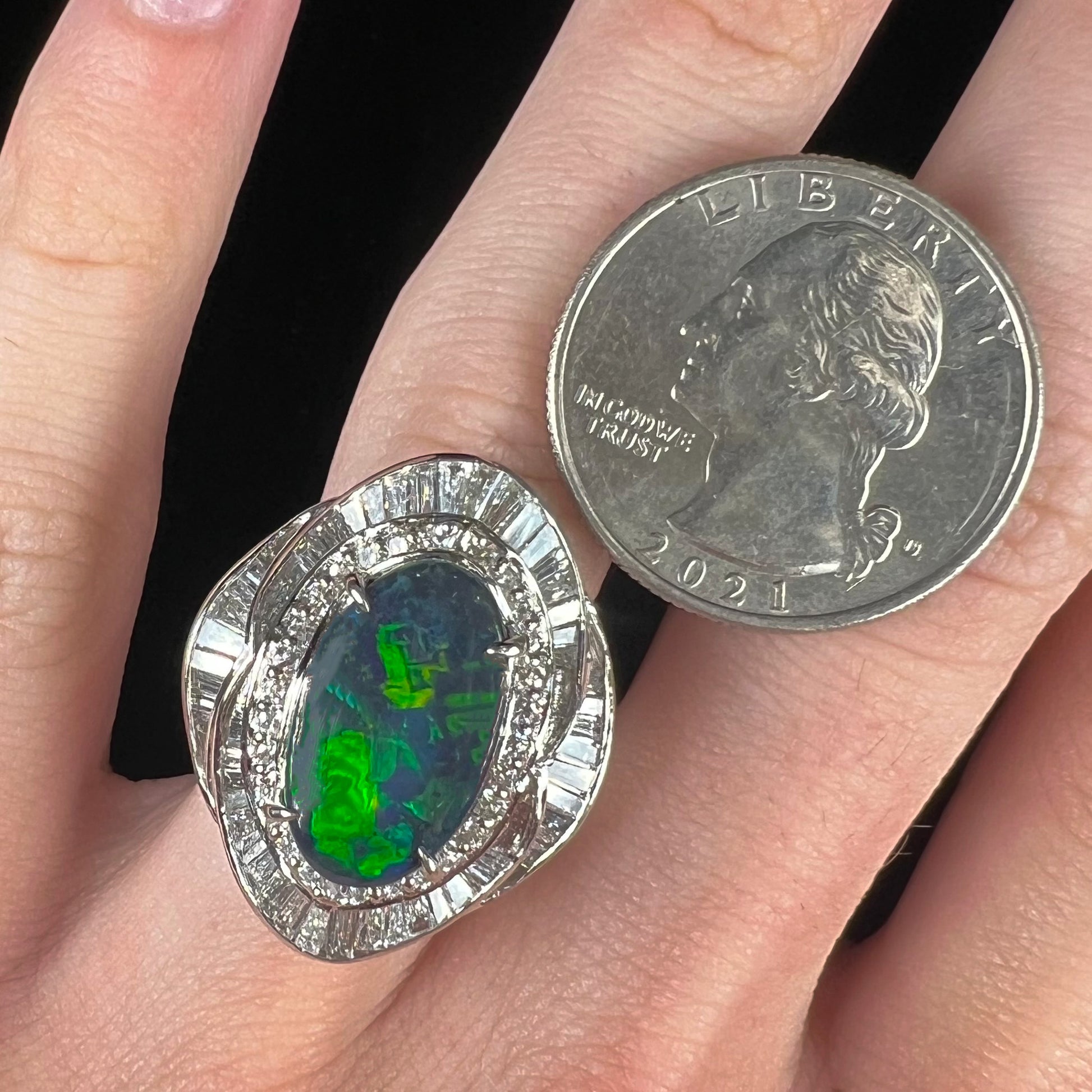 A ladies' platinum diamond halo ring set with a natural black opal stone from Lightning Ridge, Australia.