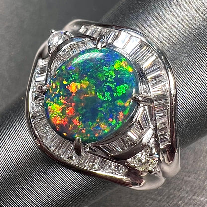 A platinum Lightning Ridge black opal ring set with baguette cut diamonds.  The opal is an oval cabochon cut.