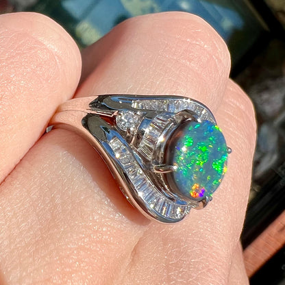 A platinum Lightning Ridge black opal ring set with baguette cut diamonds.  The opal is an oval cabochon cut.