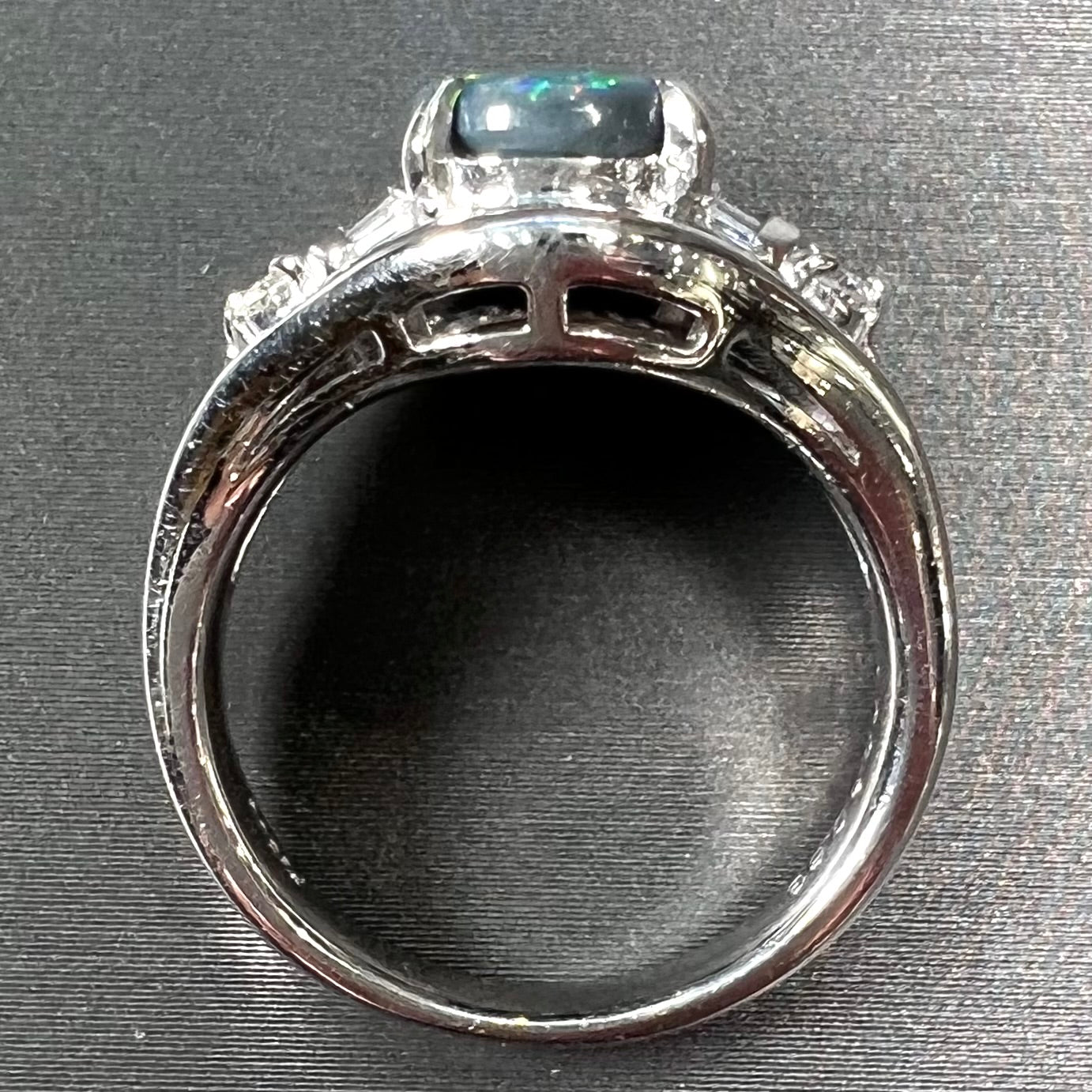 A platinum Lightning Ridge black opal ring set with baguette cut diamonds.  The opal is an oval cabochon cut.