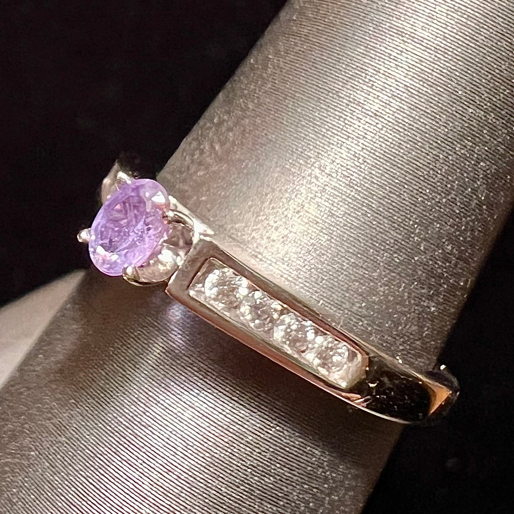 A ladies' white gold and diamond ring set with a 0.26ct alexandrite center stone that changes from green blue to lilac purple.