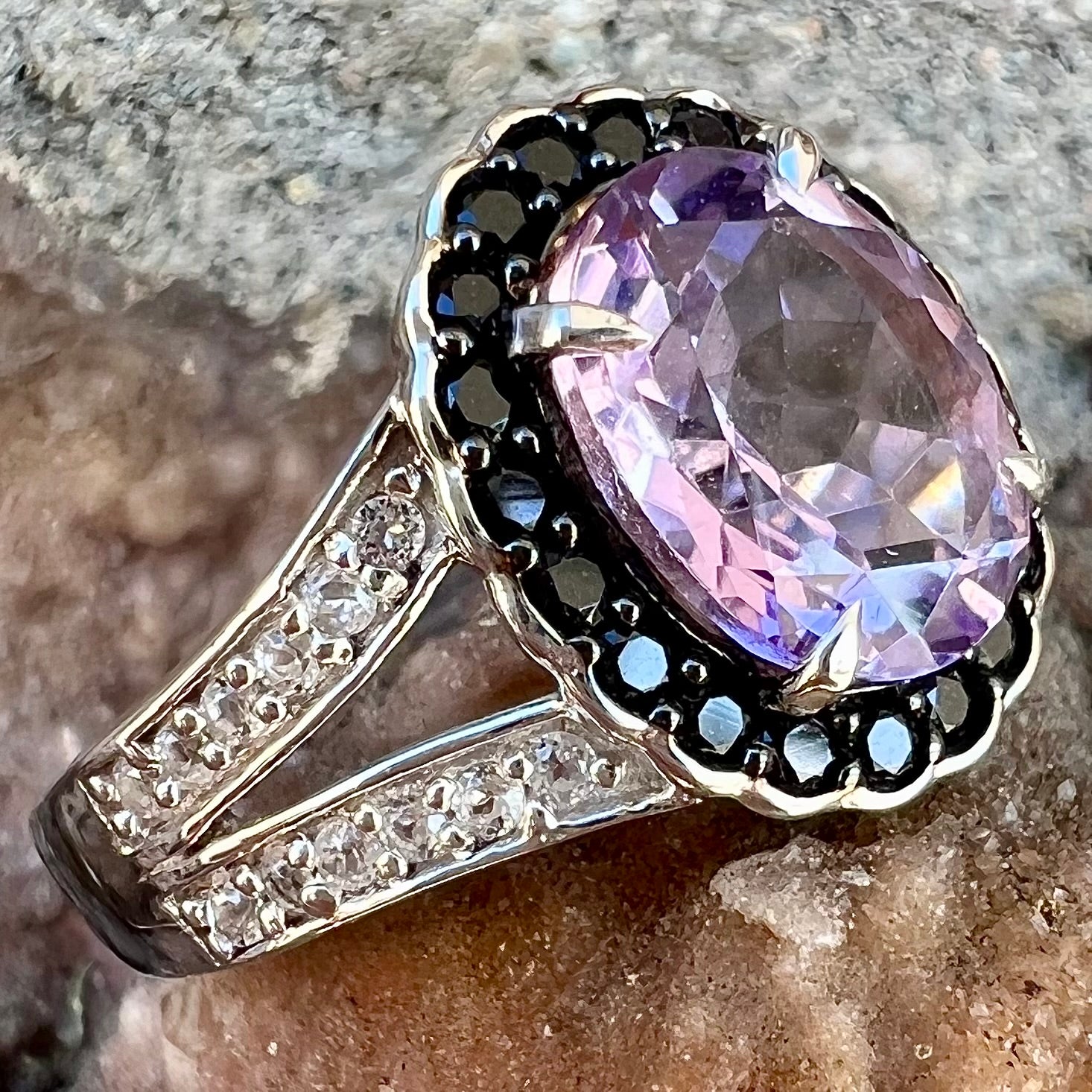 Sterling silver ladies' ring made with Rose de France amethyst set in a black spinel halo with white topaz accents.