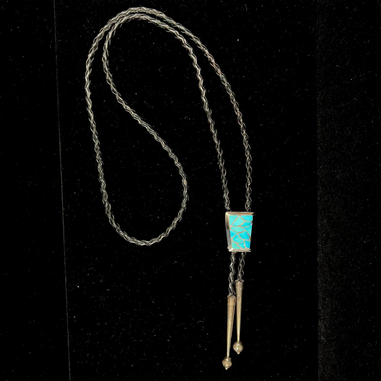 A silver turquoise inlay bolo tie handmade by Navajo artist, Lillian Fernando.