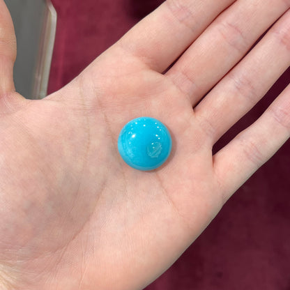 A loose, round cabochon cut turquoise stone from Sleeping Beauty Mine, Arizona.